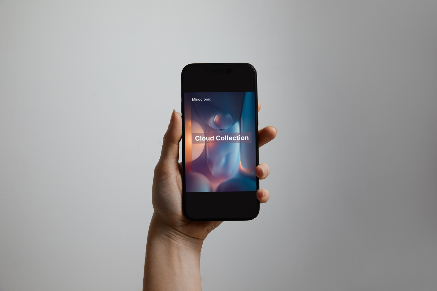 Hand holding a smartphone with 'Cloud Collection' on the screen against a gray background